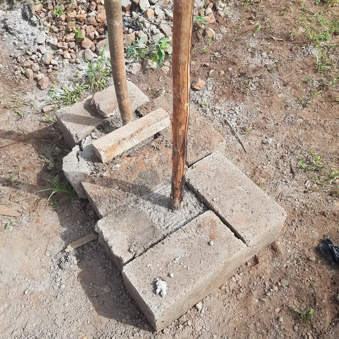 Two home-made tampers, still in their formwork of concrete blocks
