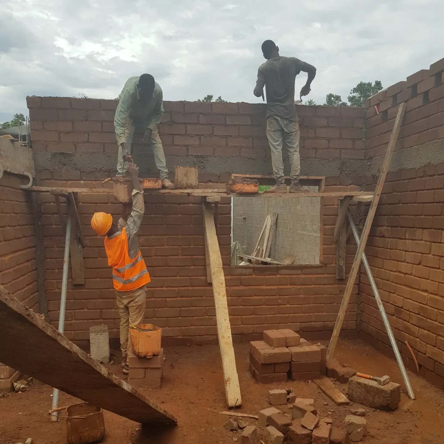 The clay bricks are being laid, and the mortar is made from the same red clay